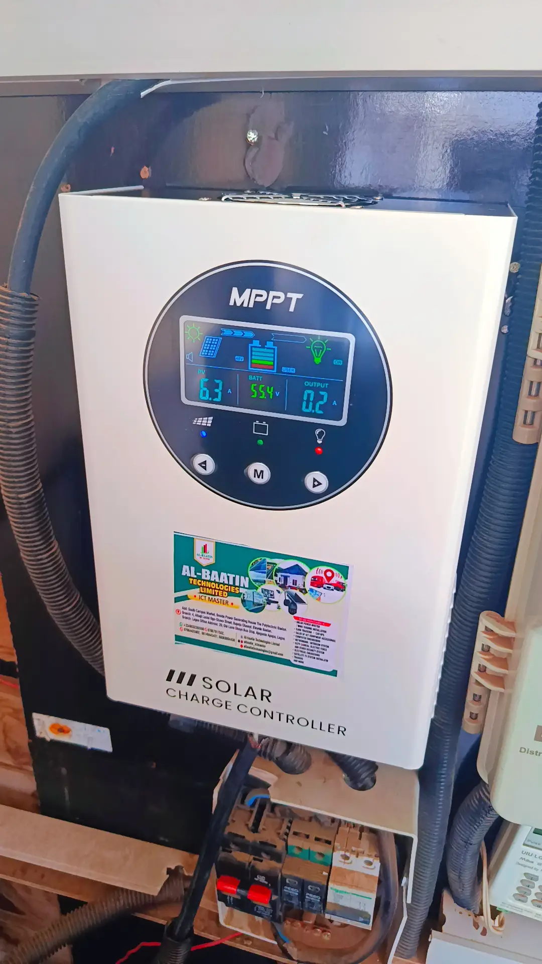 An MPPT solar charge controller mounted on a board, its display reading 6.3A from the panels and 55.4V at the battery.