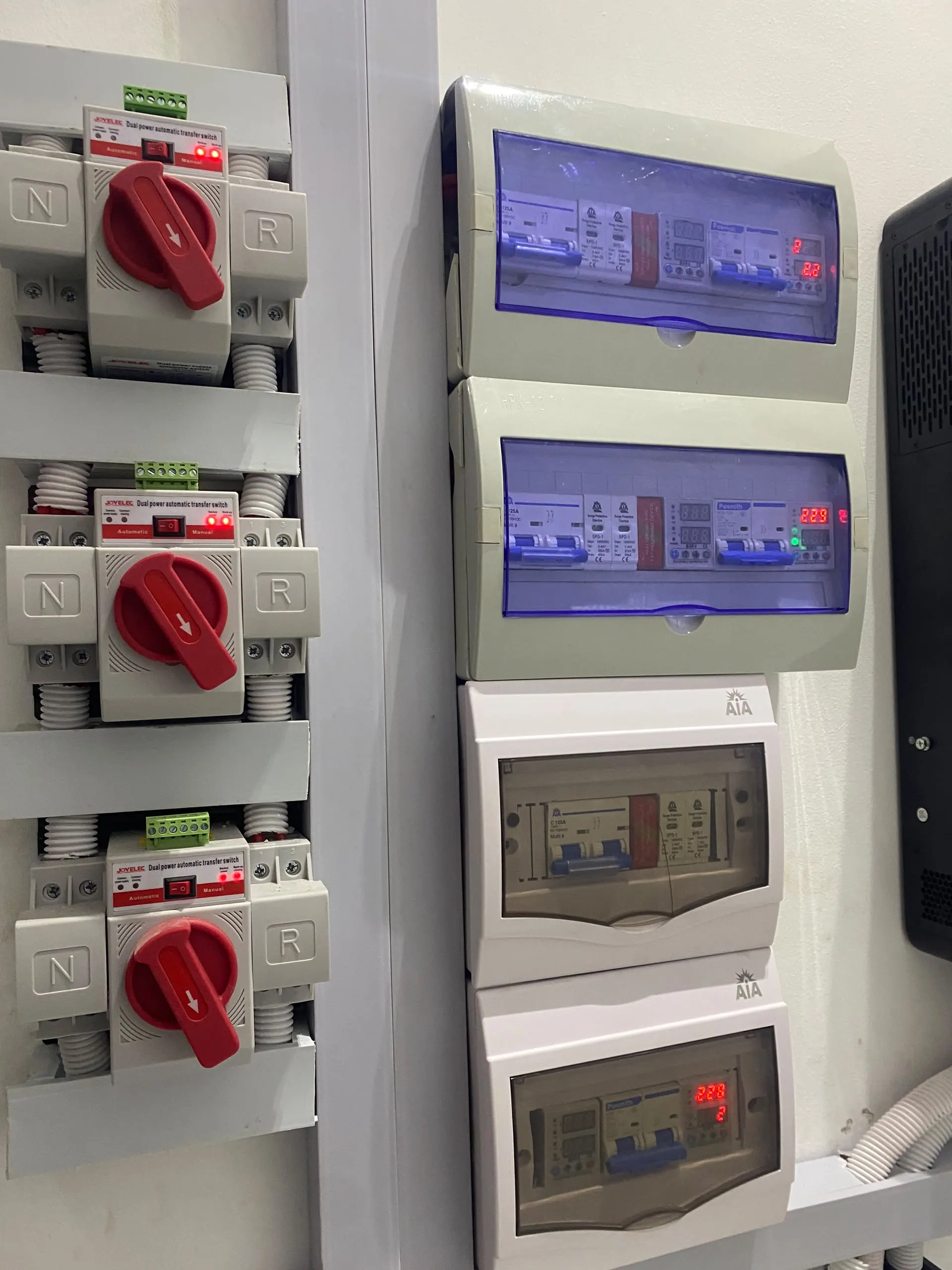 A close-up of the changeover switches and breakers on their mounting rail, each circuit labelled.