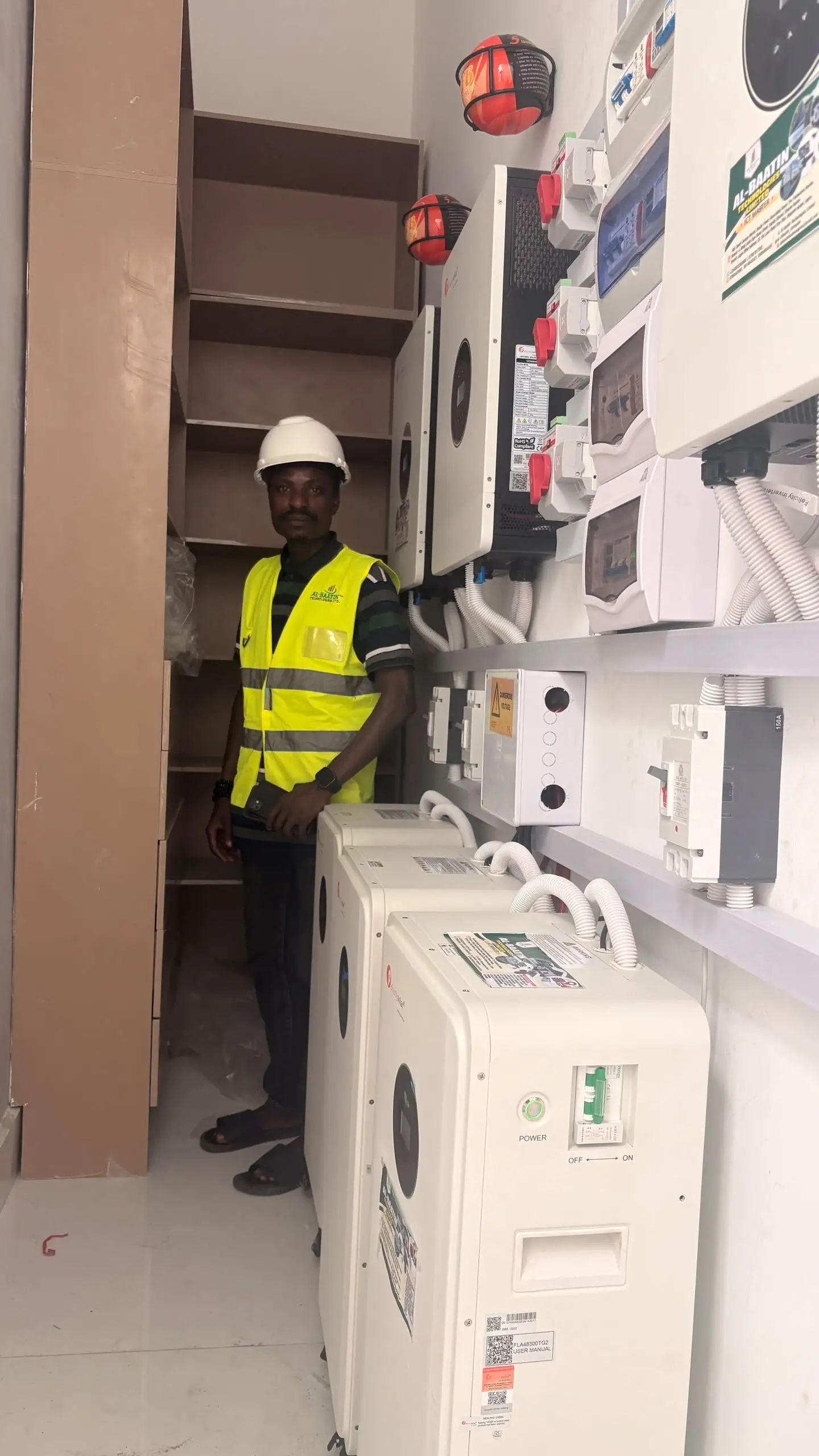 Al-Baatin standing beside the finished inverter installation.
