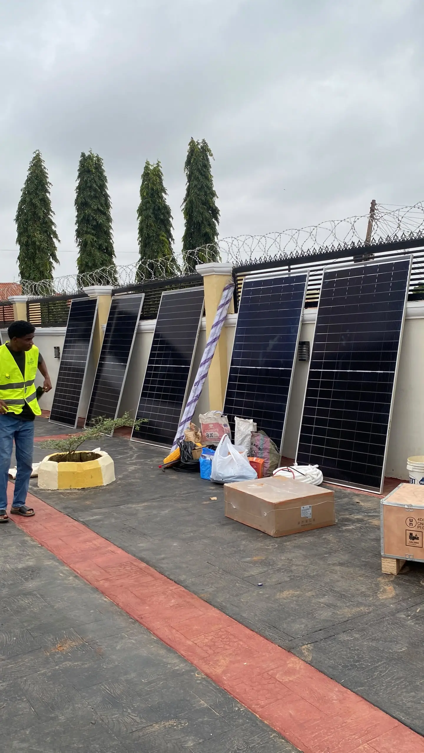 Solar panels unpacked and stacked in the compound, ready to be carried up to the roof.