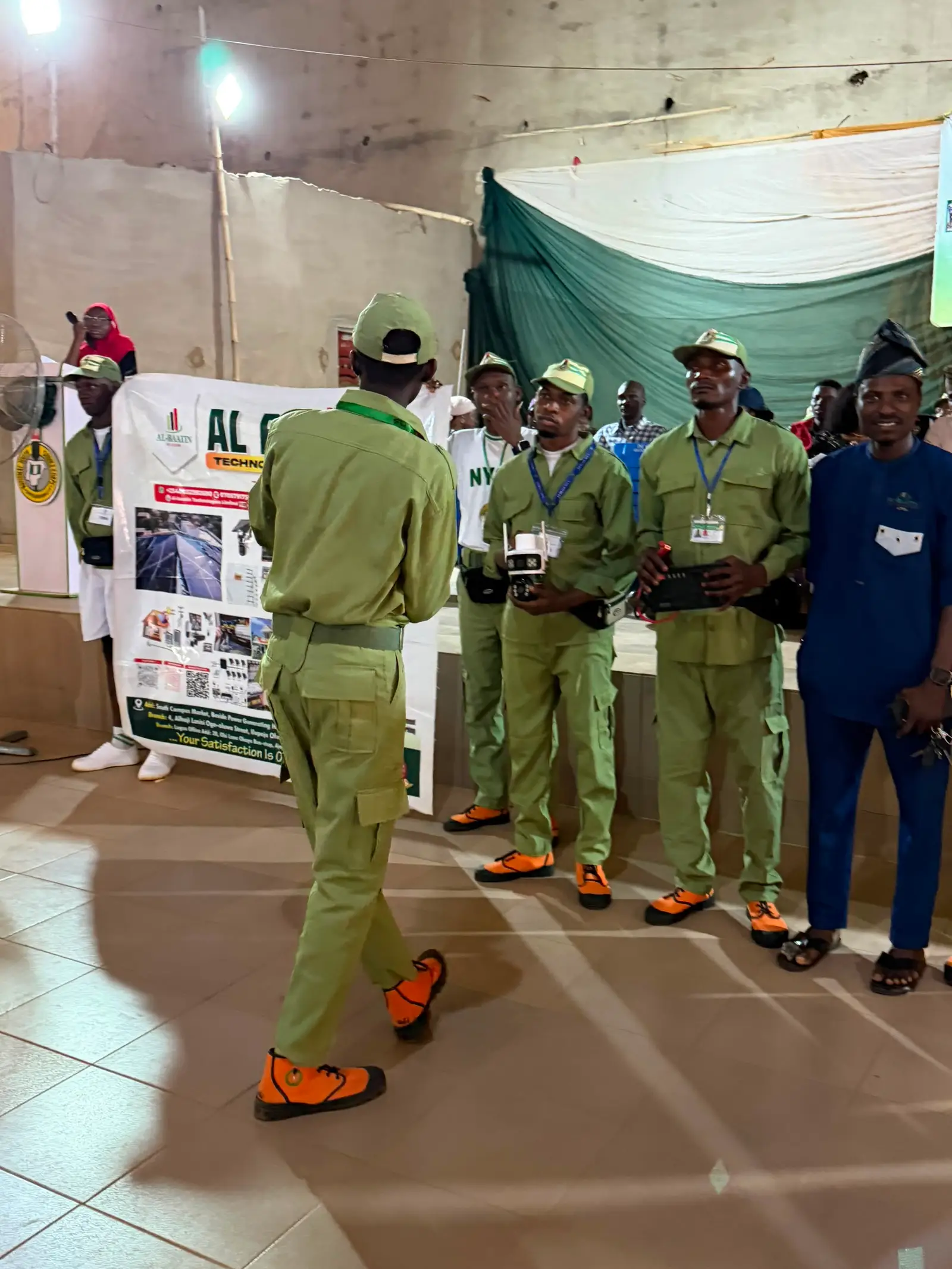 Corps members gathered at the Al-Baatin banner during a camp event.